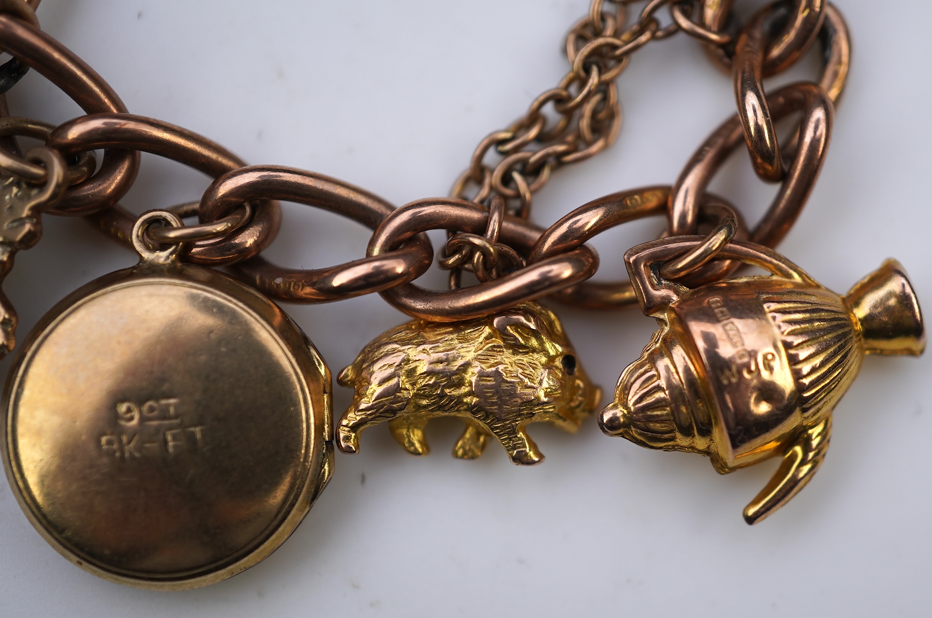 A gold charm bracelet, mid 20th century